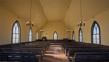the interior of a church with wooden pews
