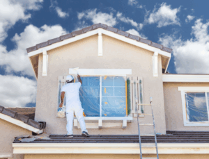 a person painting the exterior of a house