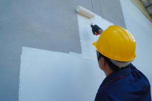 a person painting an exterior wall
